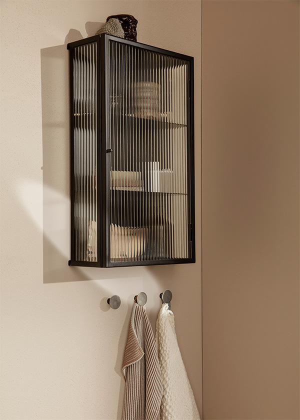 A ferm living haze wall cabinet above some hooks