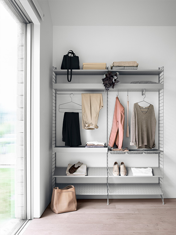 Grey string bedroom shelving filled with clothing and shoes