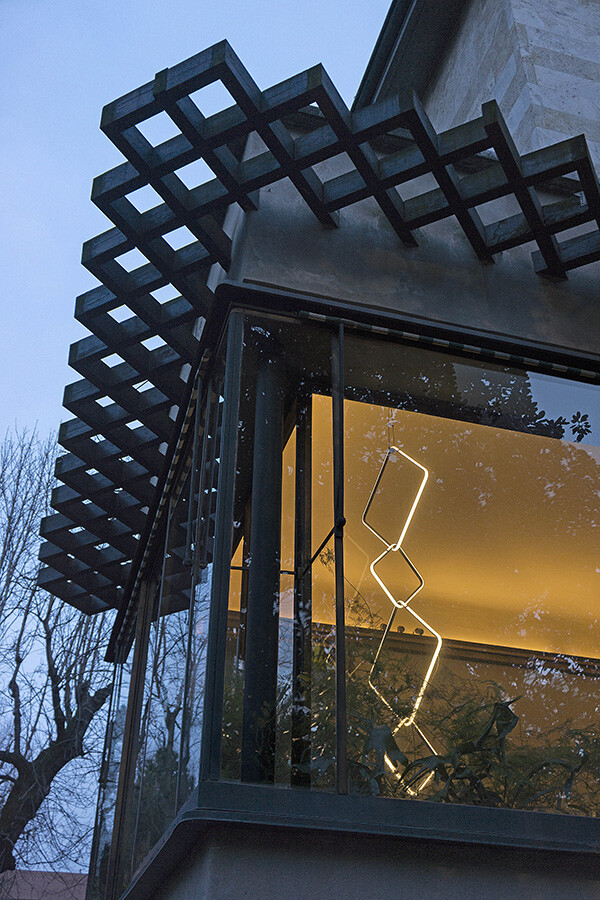 A Flos arrangements light hanging in the window of a concrete house