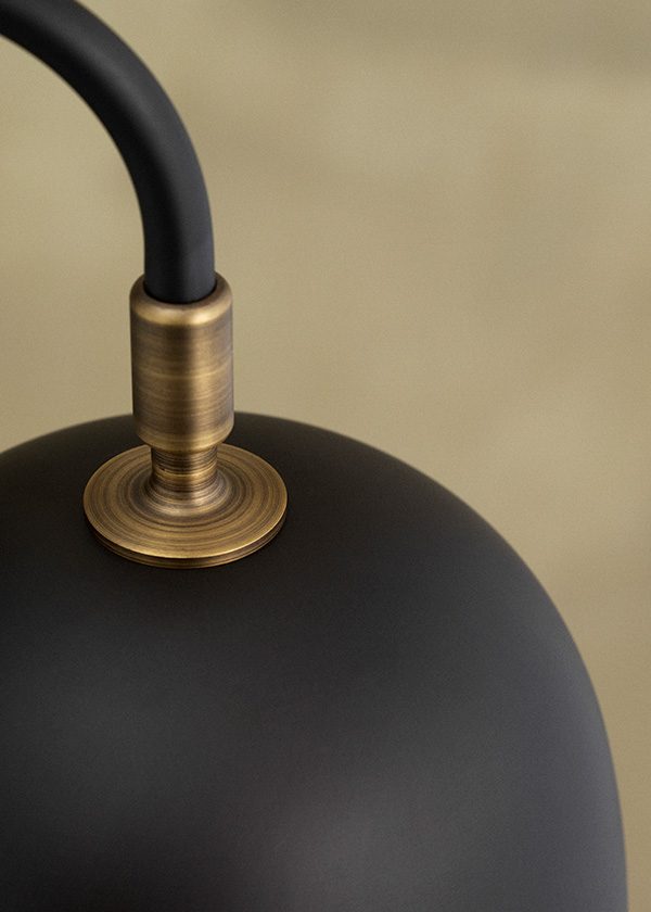 A close up of the brass shade on a GUBI Howard Chandelier