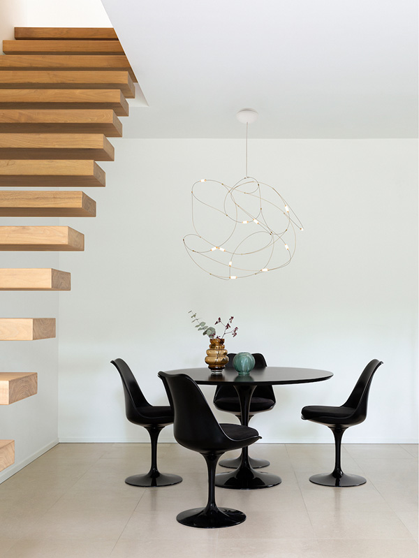 A Moooi Flock of Lights above a black Knoll Saarinen dining table and chairs
