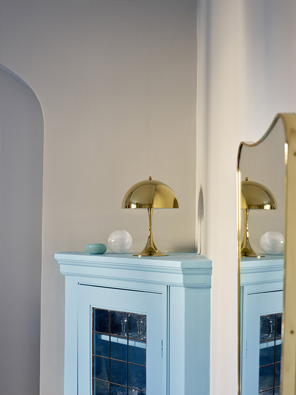 Brass Panthella 250 on top of a blue corner cabinet