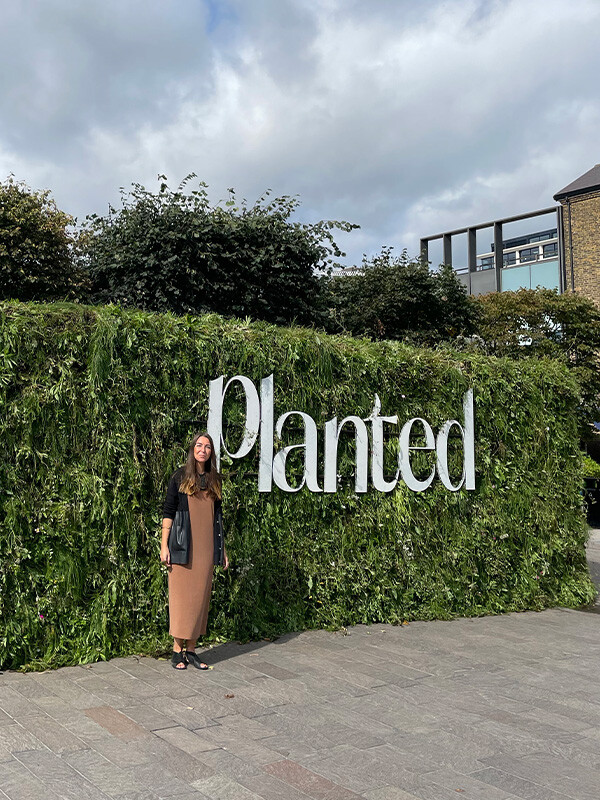Nest Marketing Manager Jessica next to a sign saying Planted