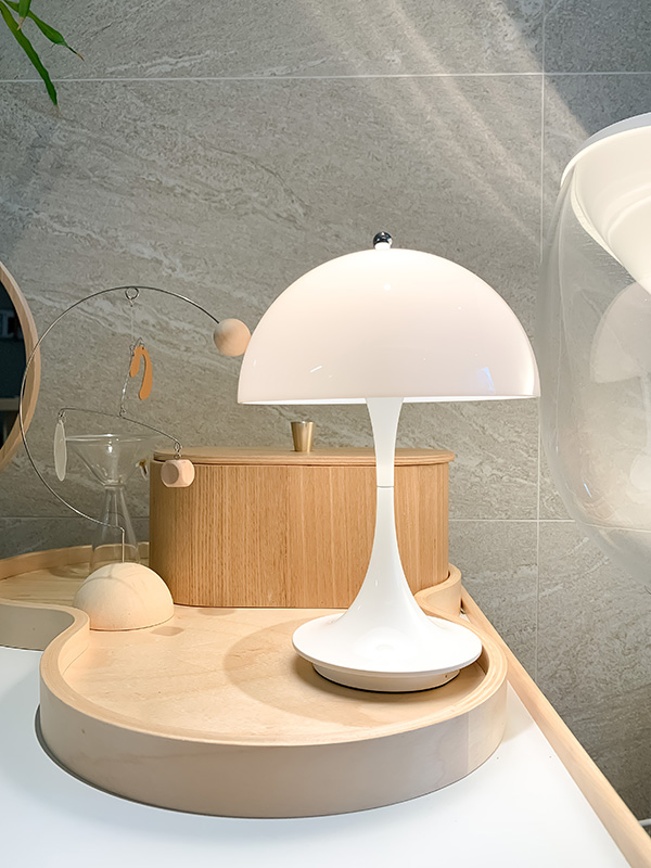 A Panthella portable table lamp on a wooden tray