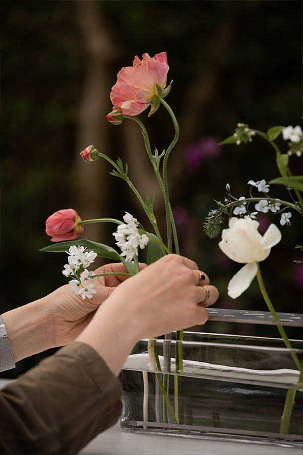 Carefully placing the stems within the Fritz Hansen Ikebana vase to create an ikebana arrangement