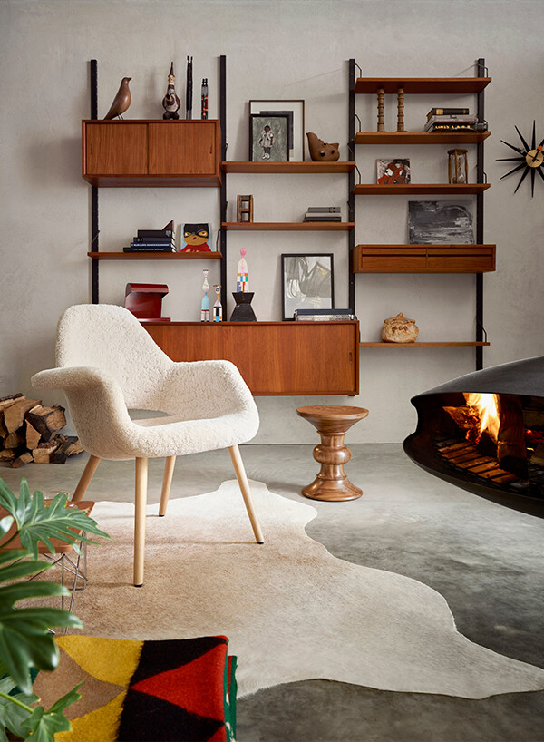 Mid-century living room with fireplace and Vitra furniture including Organic Chair in sheepskin.