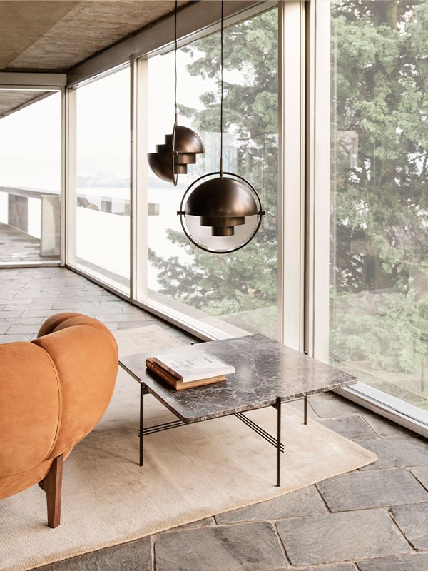 A pair of GUBI Multi-Lite pendants above side table in a minimal and modern living room