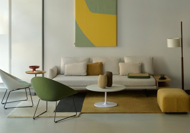 Arper modern living room furniture set featuring a cream sofa, green lounge chair, and mustard rug.