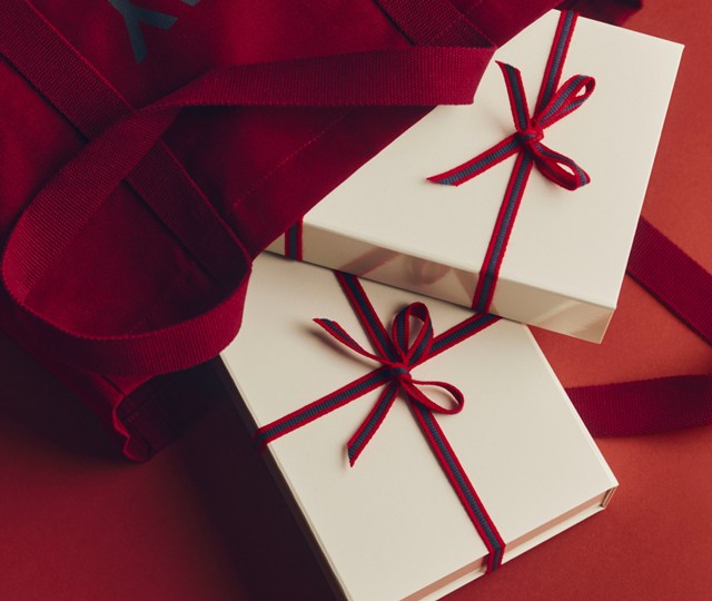 HAY wrapped gift boxes spilling out of red tote bag
