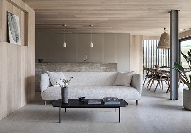 DARE Studio luxury sofa and dining set in a modern minimalist wood and concrete interior.