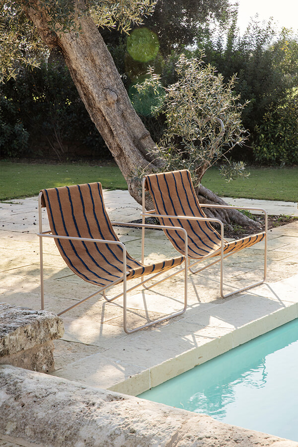 2 Ferm Living Desert Chairs next to a swimming pool