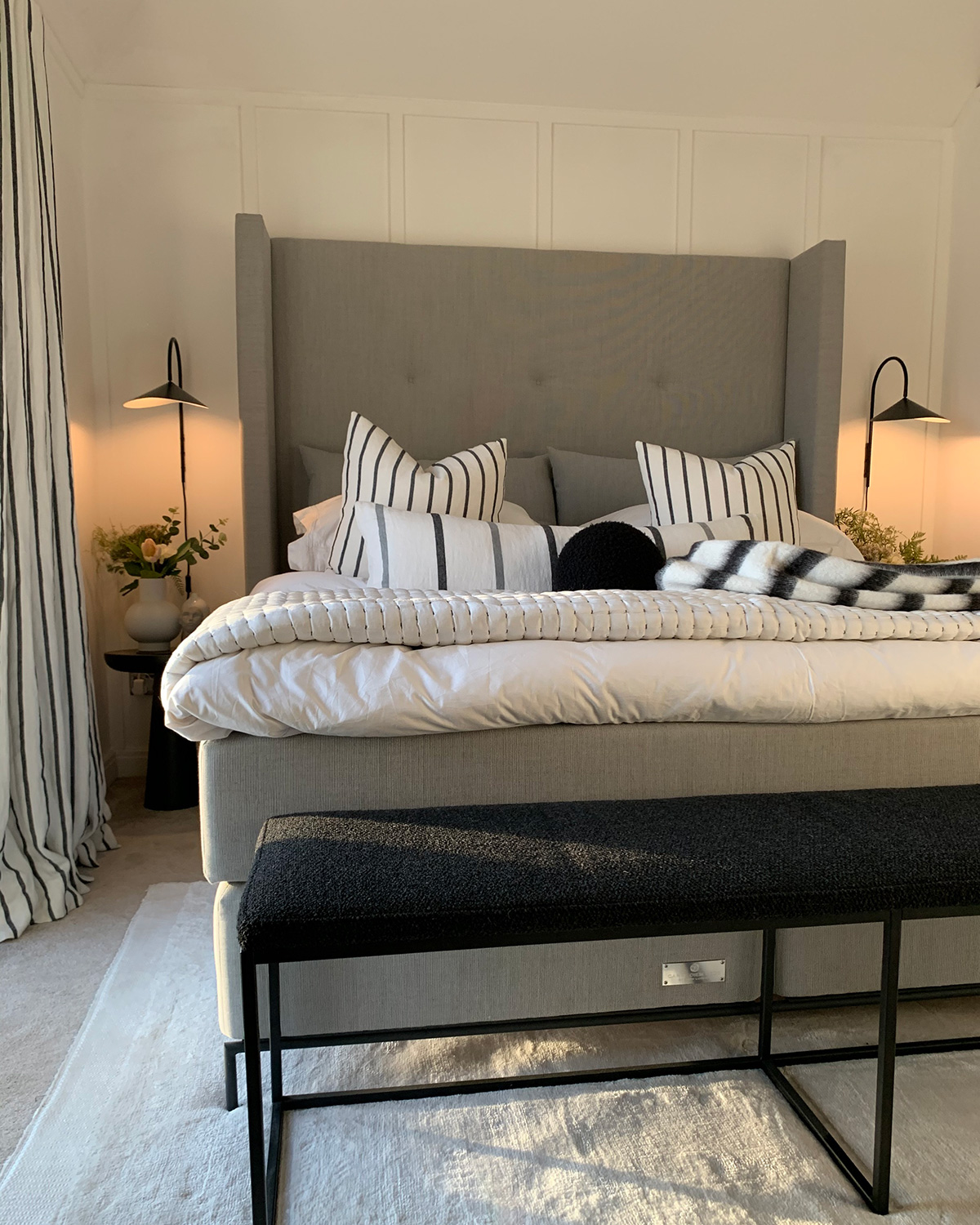 A minimal, monochrome bedroom with ferm Living Arum Wall Lamps as beside lights