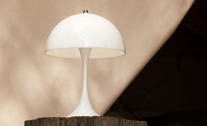 White table lamp on top of a tree stump outside