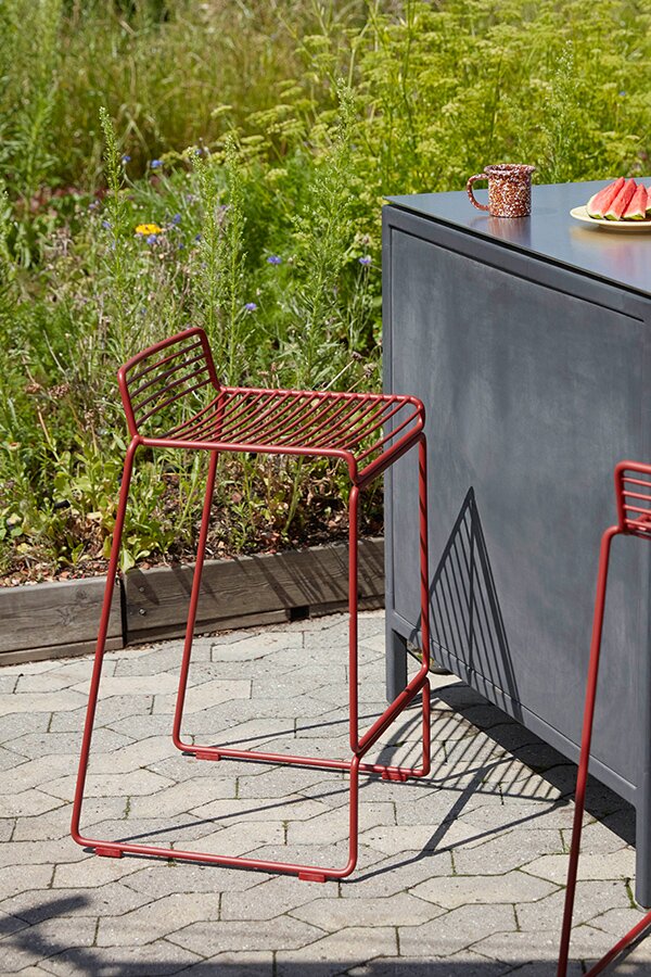 Red HAY Hee Bar Stool next to outdoor bar area