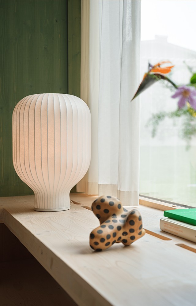 Muuto Strand Table Lamp in window setting with vase of colourful flowers