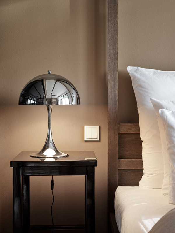 Chrome Louis Poulsen Panthella 320 Table Lamp on a bedside table