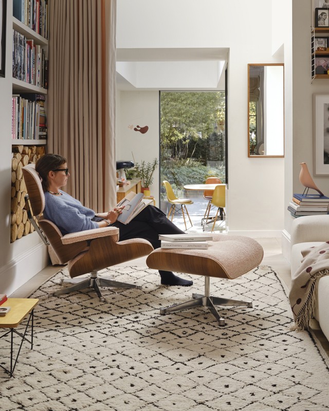 lady sat on eames lounge chair in cosy living space 