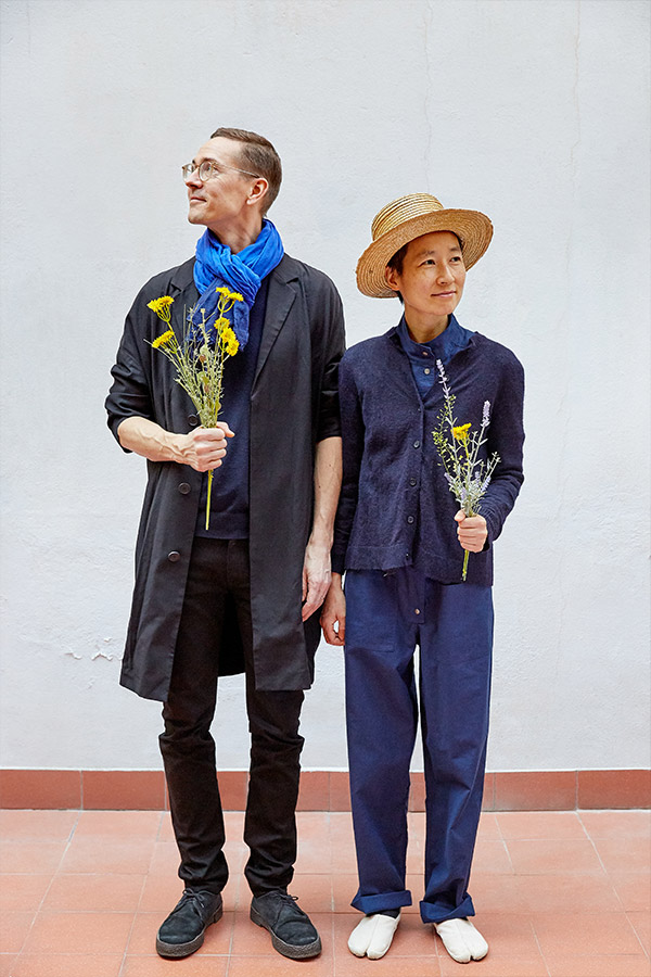 Designer portrait of Johan Olin and Aamu Song holding flowers