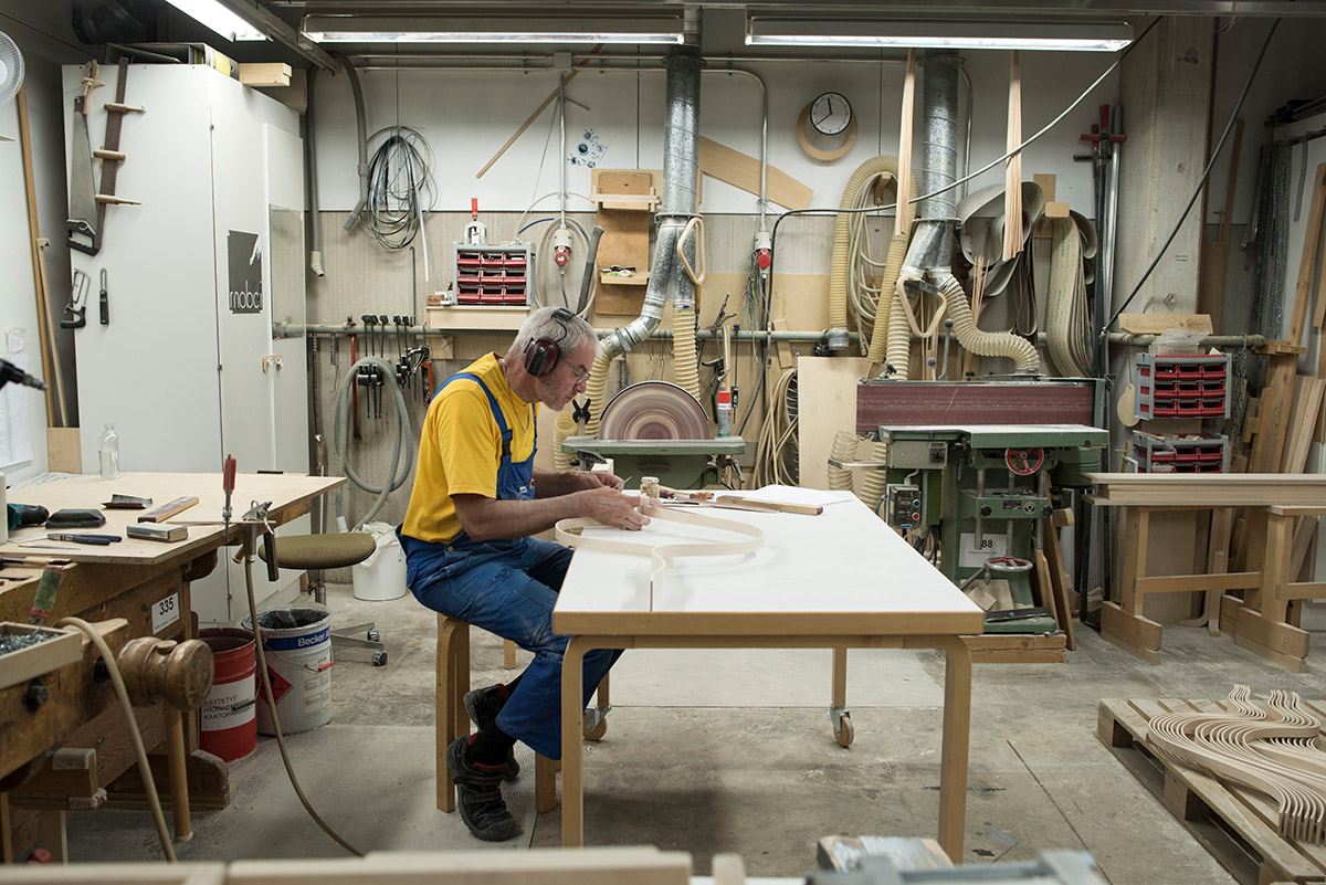 a man sat at a desk making something inside the artek factory