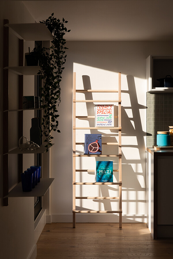 Sun shining on a wooden ladder shelving system in the Park Hill show apartment