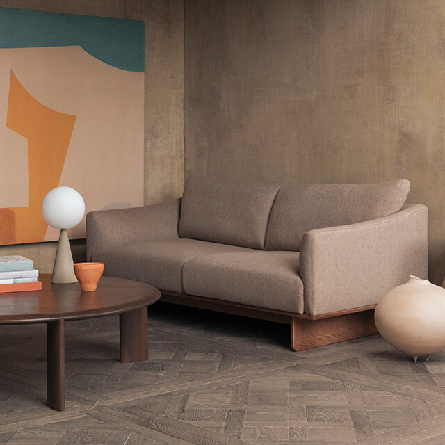 Ercolani Grade Two Seater Sofa in living room with lime-washed walls and abstract artwork 