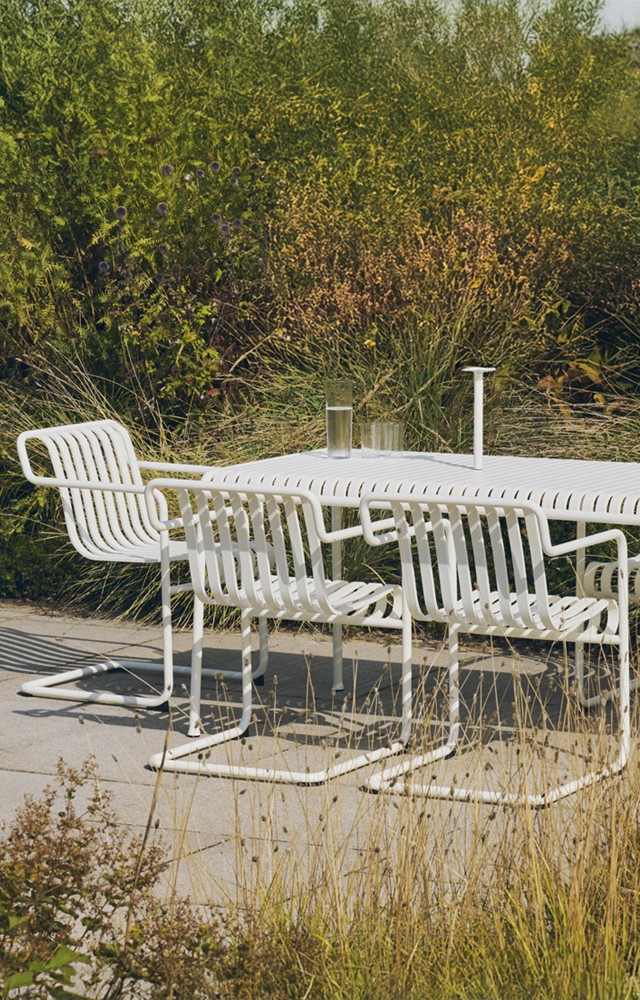 HAY Palissade Dining Table with Cantilever chairs & dining chairs in lush green setting 