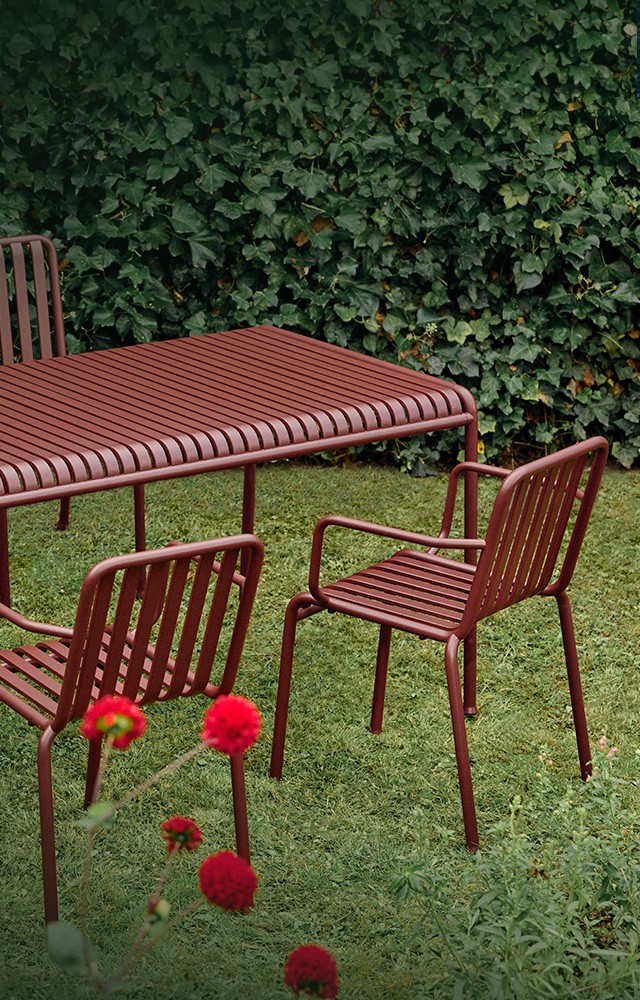 HAY Palissade collection in an outdoor setting with an Iron Red finish