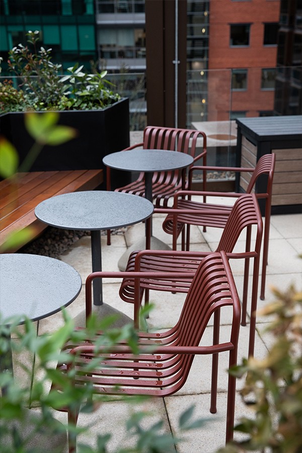 Outdoor piazza at Pall MAll Workspace featuring HAY Palissade seating in iron red