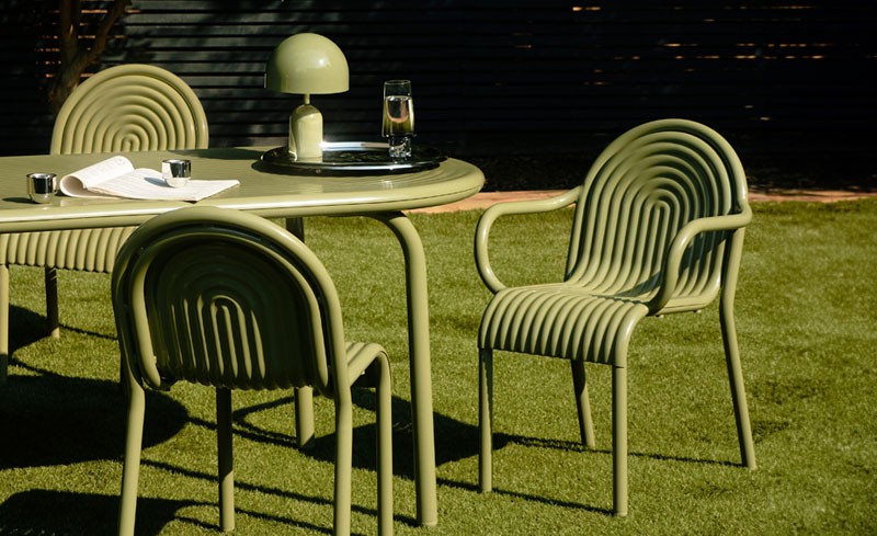 Green Tom Dixon Groove Outdoor furniture set in a sunlit garden