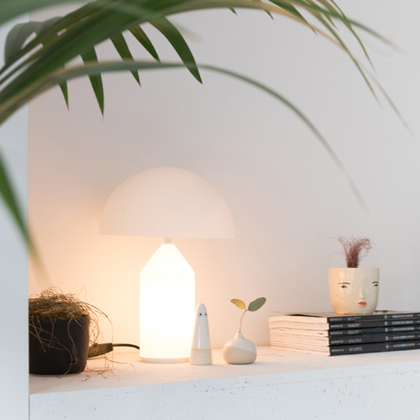 Oluce Atollo table lamp in white on a sideboard