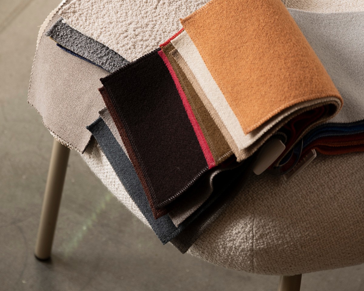 Ferm Living Upholstery swatch book displayed across a dining chair 