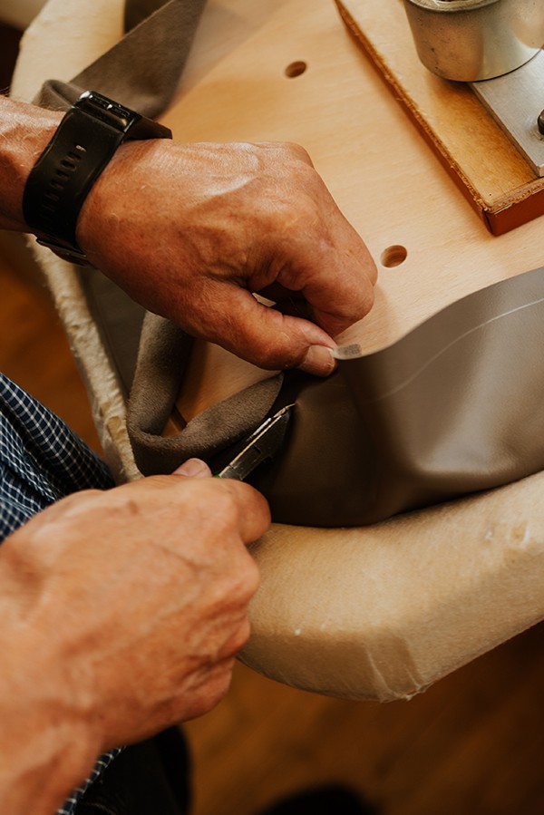 Detail shots of Finn Juhl team crafting leather upholstered designs - trimming & tucking
