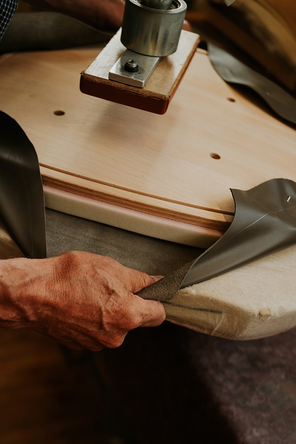 Detail shots of Finn Juhl team crafting leather upholstered designs - covering with leather