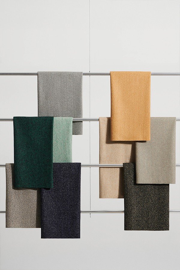 Collection of textiles arranged over metal rods for display