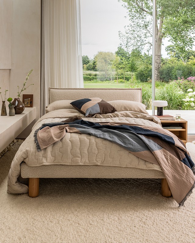 New to Nest - Case Somme Bed in bedroom setting with spring garden backdrop