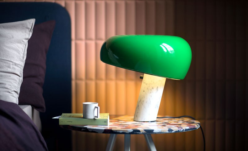 Green Flos Snoopy Lamp on a bedside table