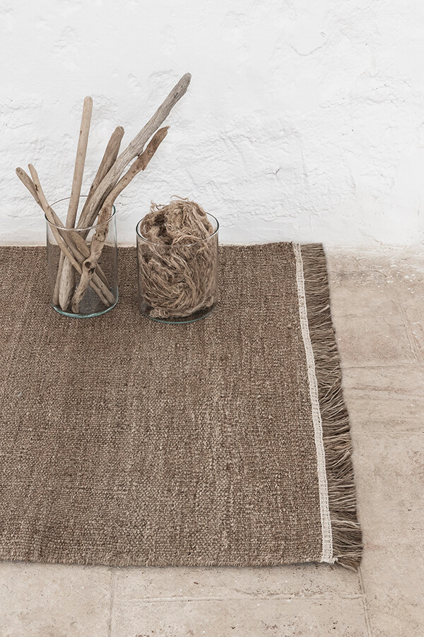 Detail of the nanimarquina Wellbeing Nettle Dhurrie Rug on a hard floor